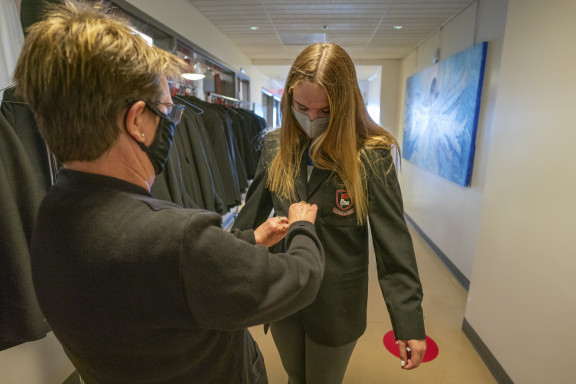 Brentwood's head seamstress helps fit a student with a new blazer