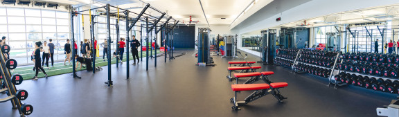 A wide view of the entire gym with weights and machines