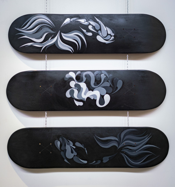 Three skateboards painted in black and grey