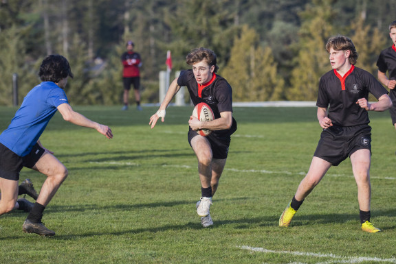 A boy running with the rugby ball